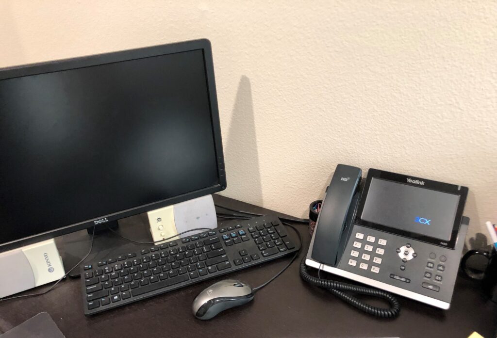 This is a photo of a computer and phone symbolizing ways to contact us for technical support.